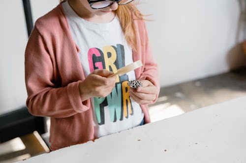 Free Girl in Pink Sweater Holding a Magnifier and a Rock Stock Photo