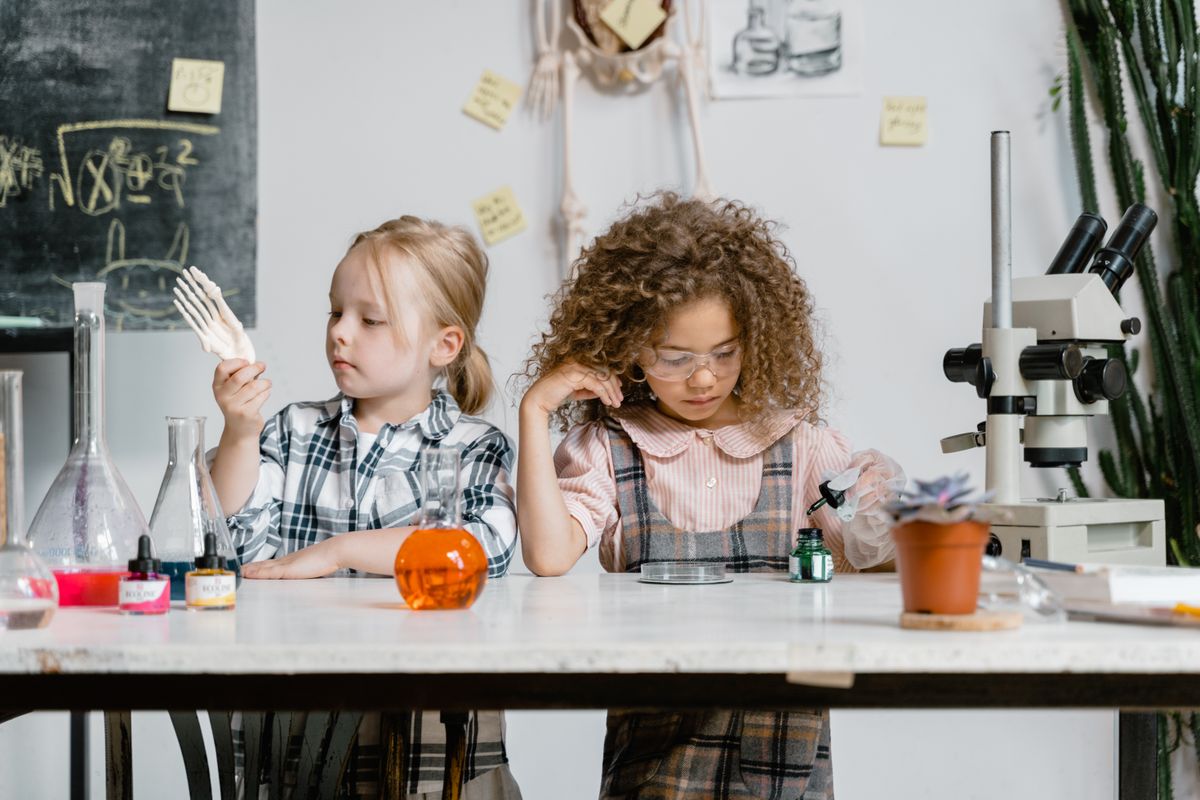 Two school students exploring laboratory equipment during a science experiment