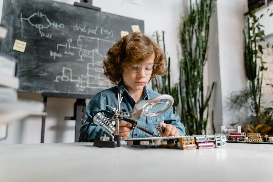 Curious child exploring electronics and circuits in a classroom setting, showcasing early STEM learning. Curious child exploring electronics and circuits in a classroom setting, showcasing early STEM learning.