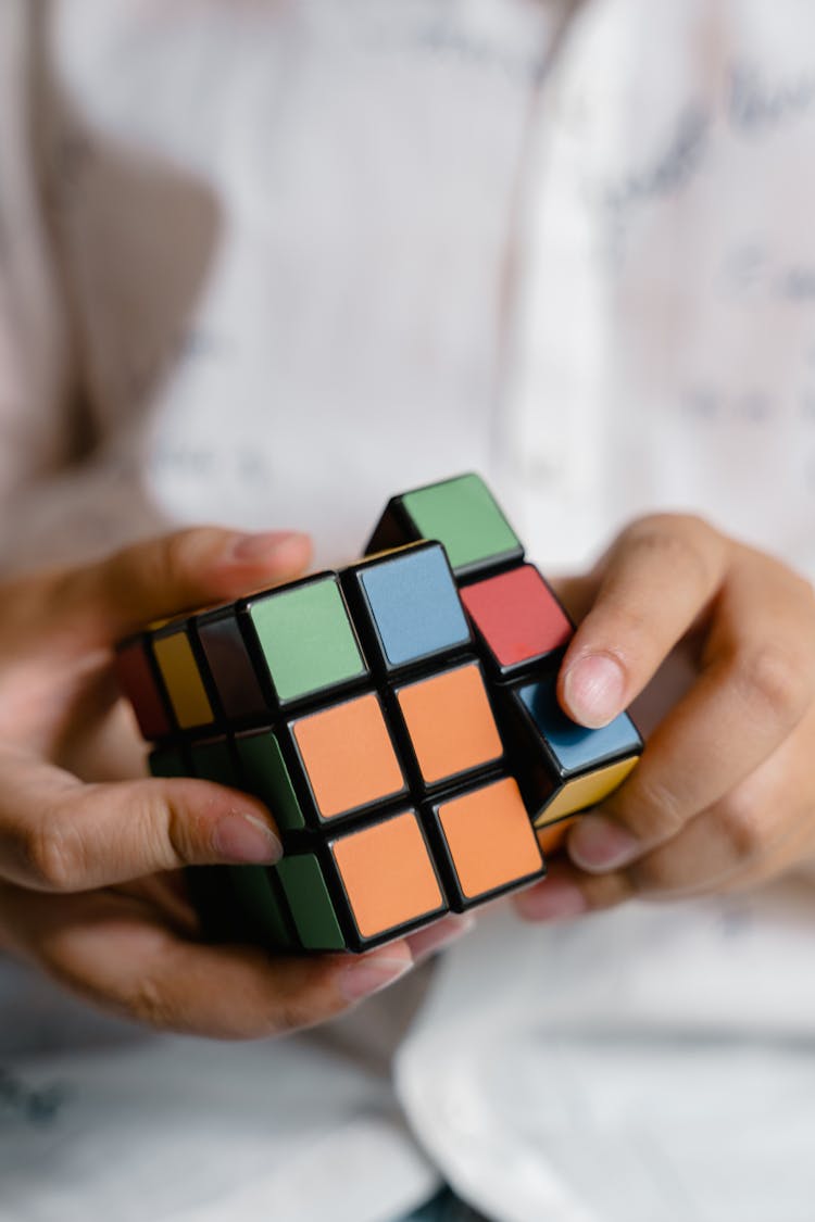 A Person Playing With A Rubiks Cube