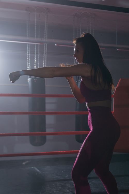 Free Fitness-focused woman practicing boxing in a gym, showcasing athleticism and power. Stock Photo