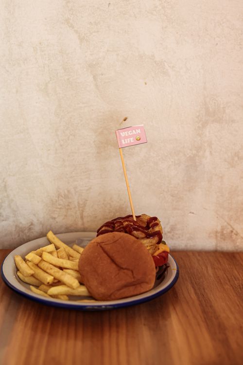 Free A delicious vegan burger with fries on a plate with a rustic background, ideal for food photography. Stock Photo