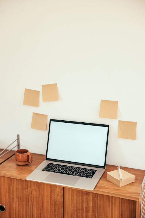 Laptop and Sticky Notes on Wooden Work Desk