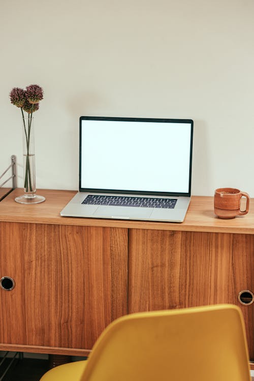 Free Laptop and a Beverage Placed on Top of a Wooden Work Desk Stock Photo