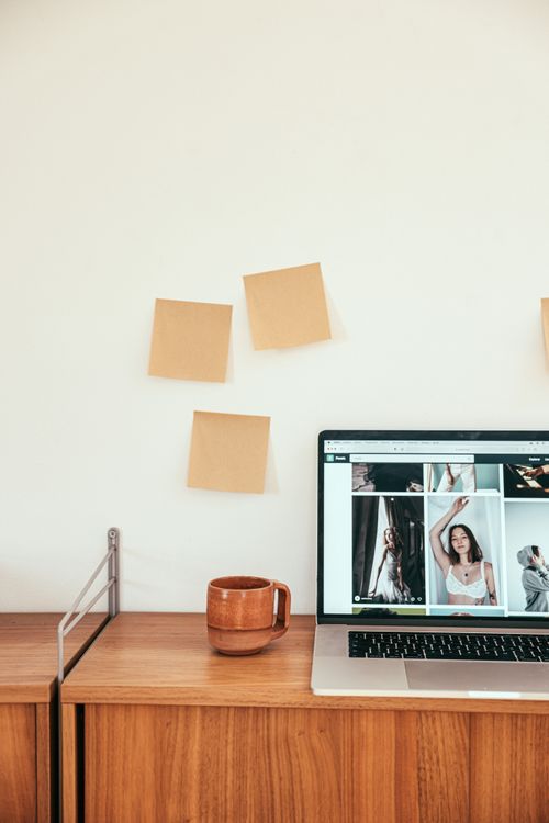 Free A minimalist workspace features a laptop, sticky notes, and a wooden desk, ideal for remote work inspiration. Stock Photo