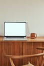A Laptop and Mug on a Wooden Table
