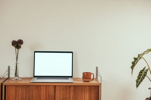 Free A clean, minimalist workspace with a laptop and coffee mug on a wooden desk for productivity. Stock Photo