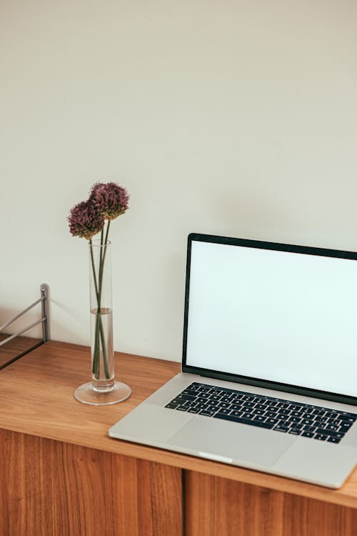 Free A Laptop beside a Flower Vase Stock Photo