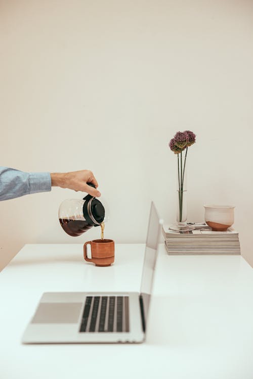 A Person Pouring Coffee in a Cup
