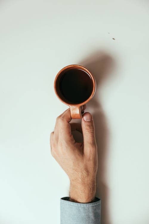 Persona Che Tiene Una Tazza Di Caffè Nero