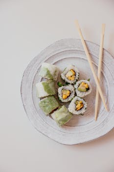 A top-down view of sushi rolls served with chopsticks on a rustic plate, showcasing Japanese cuisine.