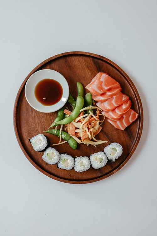 Free Japanese cuisine with sushi, sashimi, and edamame on wooden plate. Stock Photo