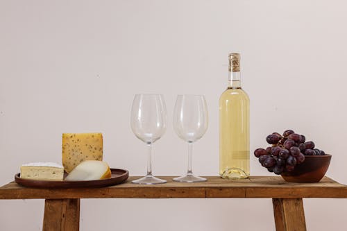 Cheese and Grapes on Table with Bottle of White Wine