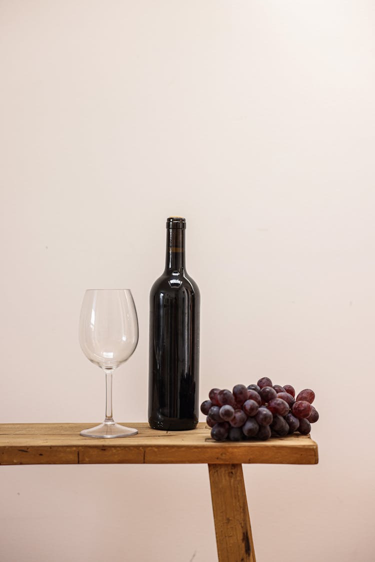 Photo Of A Bottle Beside Grapes And A Wine Glass