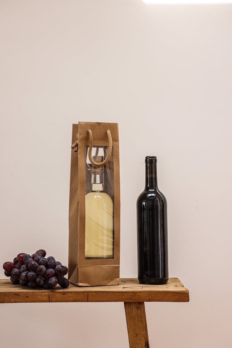 Grapes, A Bag And A Bottle Of Wine On A Table