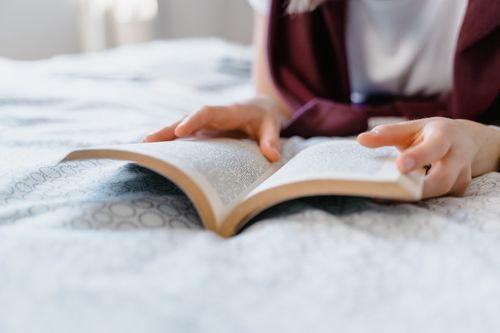 Free A person leisurely reading a book in bed, enjoying a peaceful indoor setting. Stock Photo