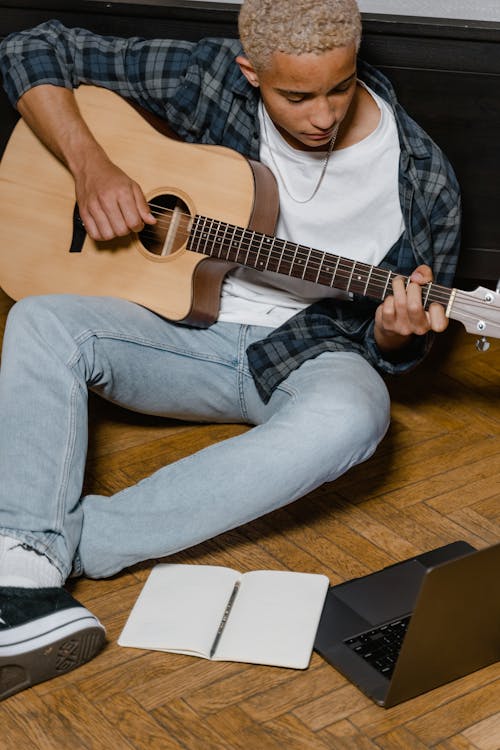 Gratis lagerfoto af afroamerikansk mand, akustisk guitar, bærbar computer Lagerfoto