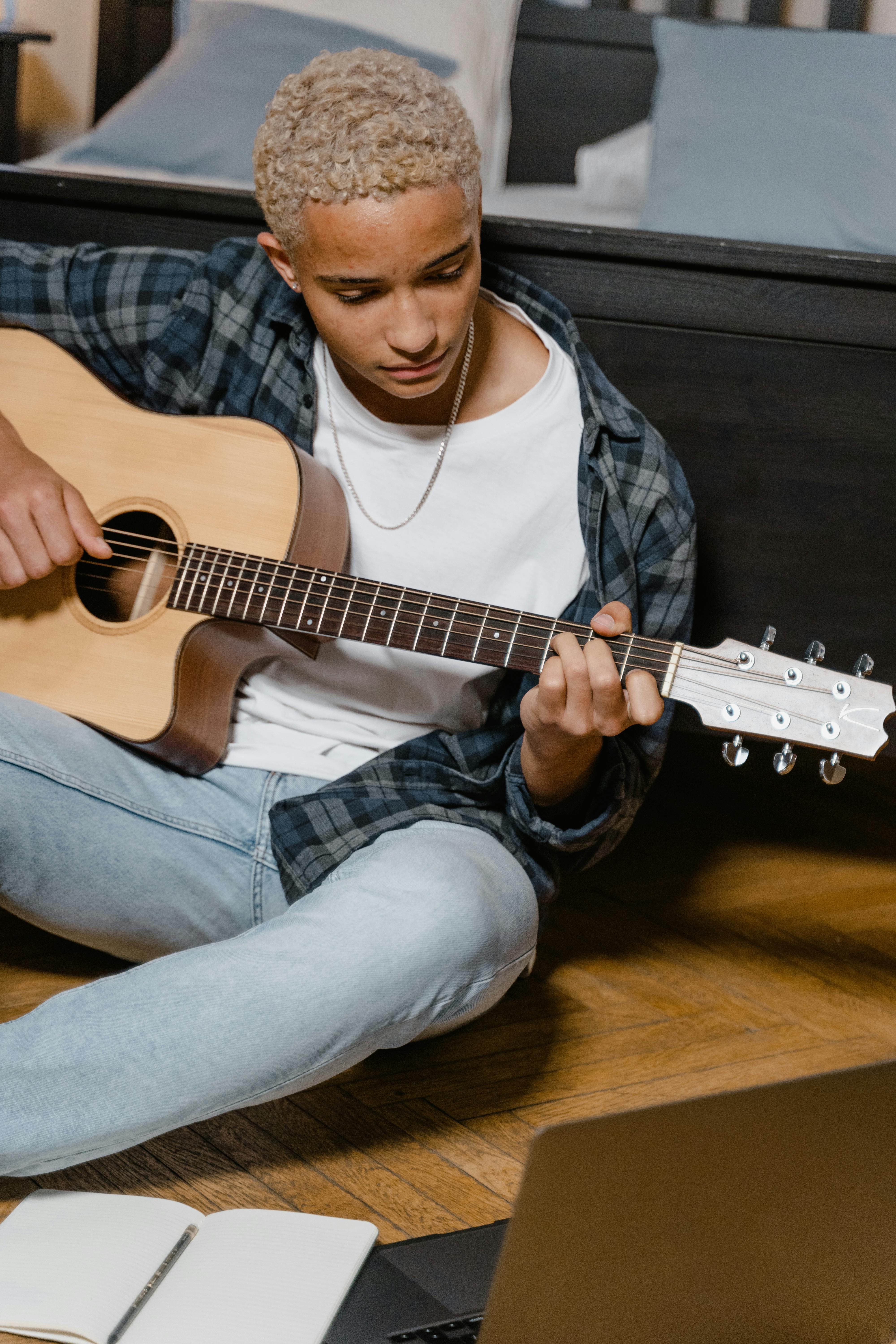 man in blue denim jacket playing guitar