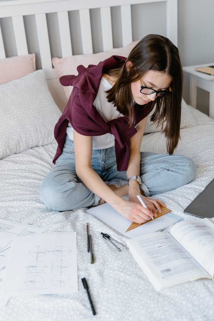 A Young Woman Drawing In A Notebook With A Set Square