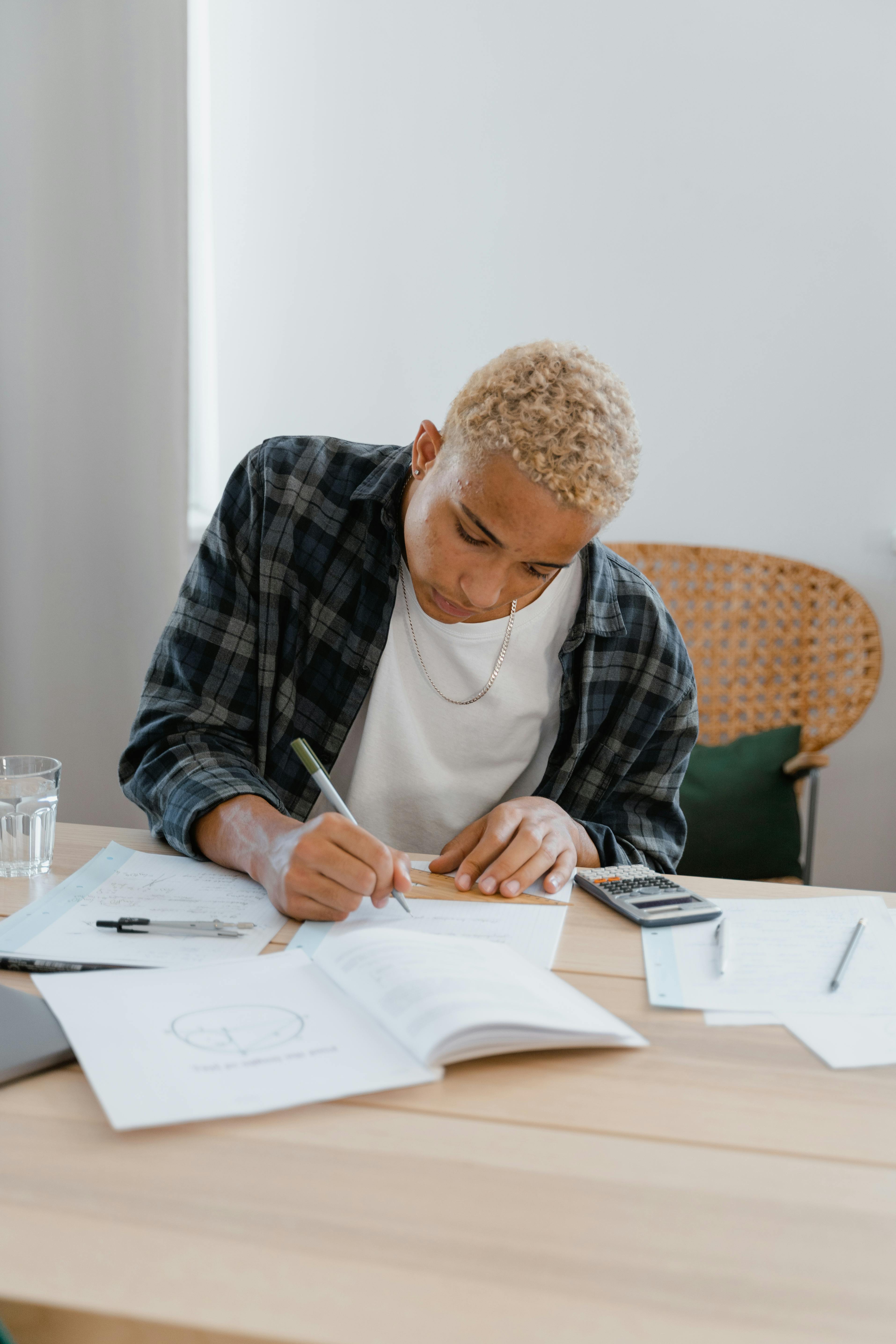 man in white shirt writing on paper