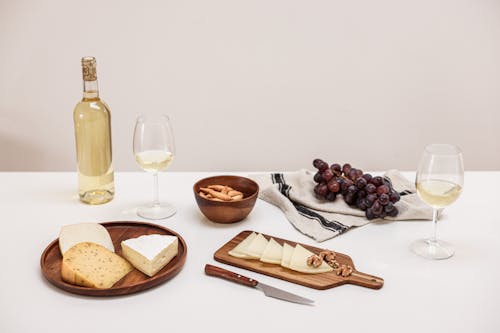 Free An Assorted Cheese and Grapes on the Table with Wine Glasses Stock Photo