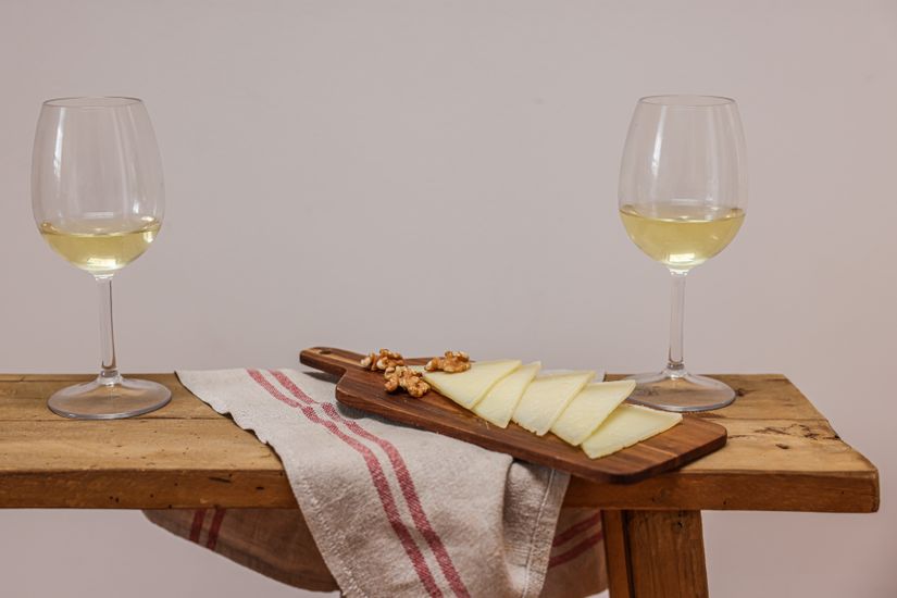 White wine glasses placed near a cheese board