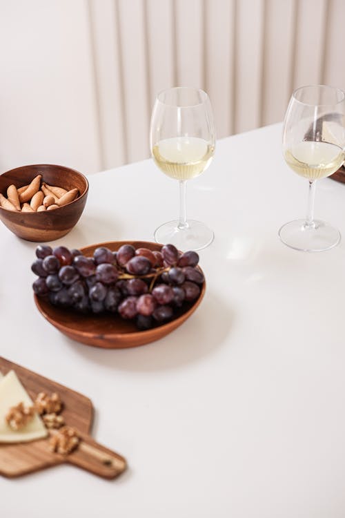 Glasses of White Wine and a Bowl of Grapes