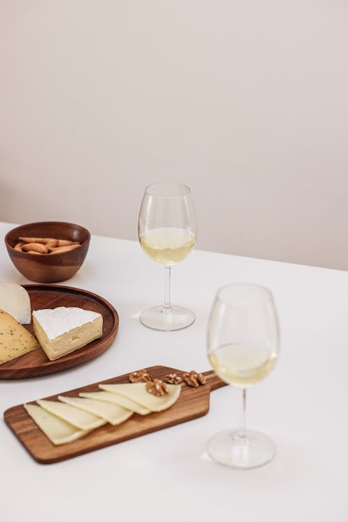 Free Glasses of Wine and a Variety of Cheese on a Table Stock Photo