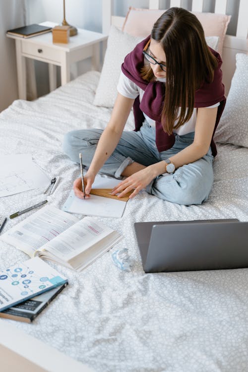 A Young Woman Drawing in a Notebook with a Set Square