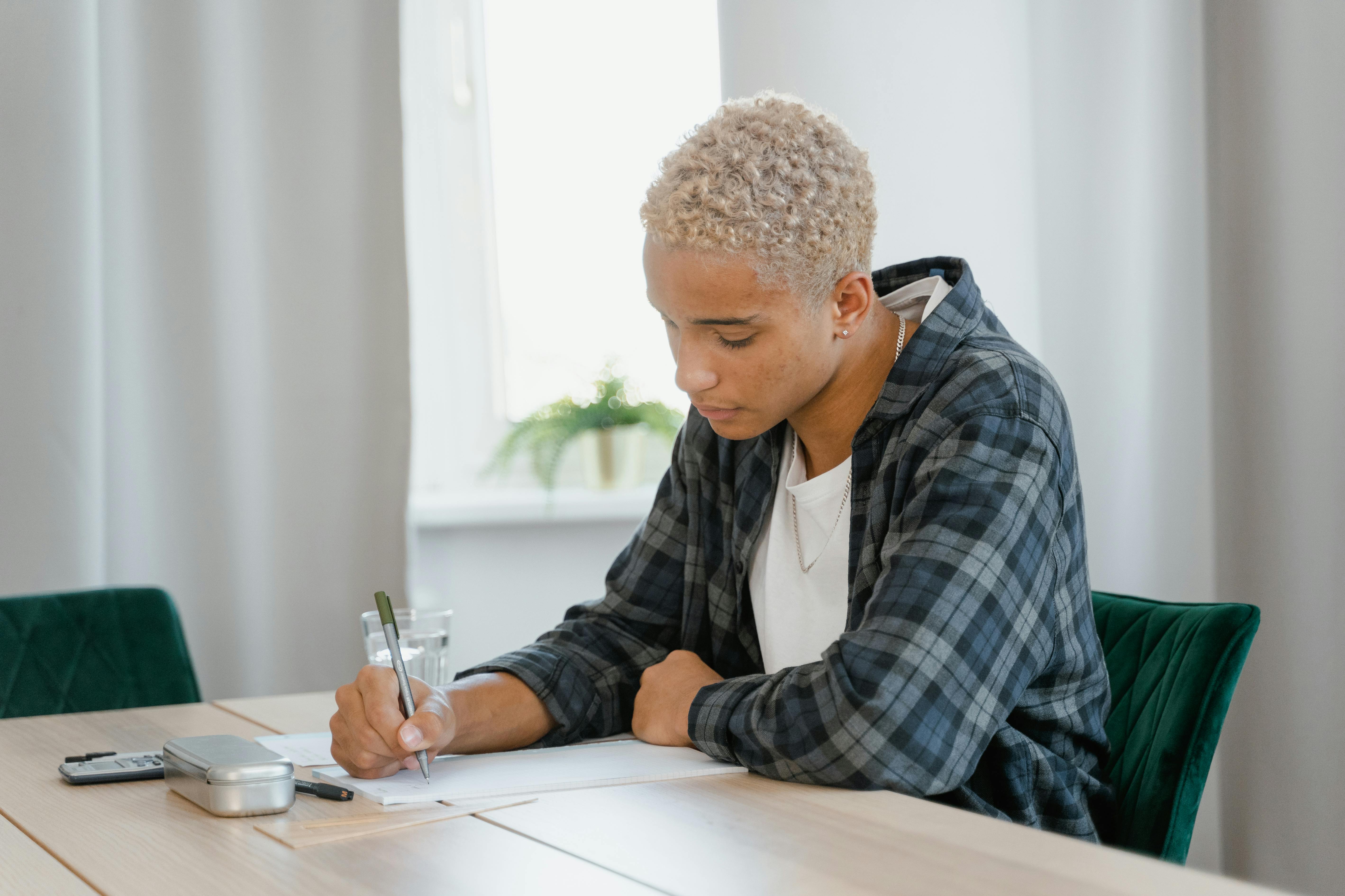 a young man doing his homework on a table