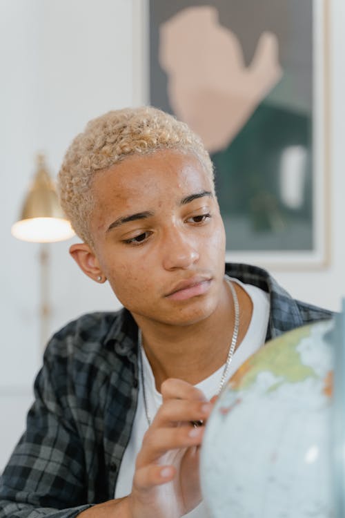 Close-up of a Young Man Looking at a Globe
