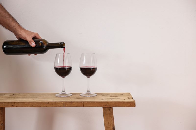 Vino rosso della Valtellina versato nei bicchieri su un tavolo di legno