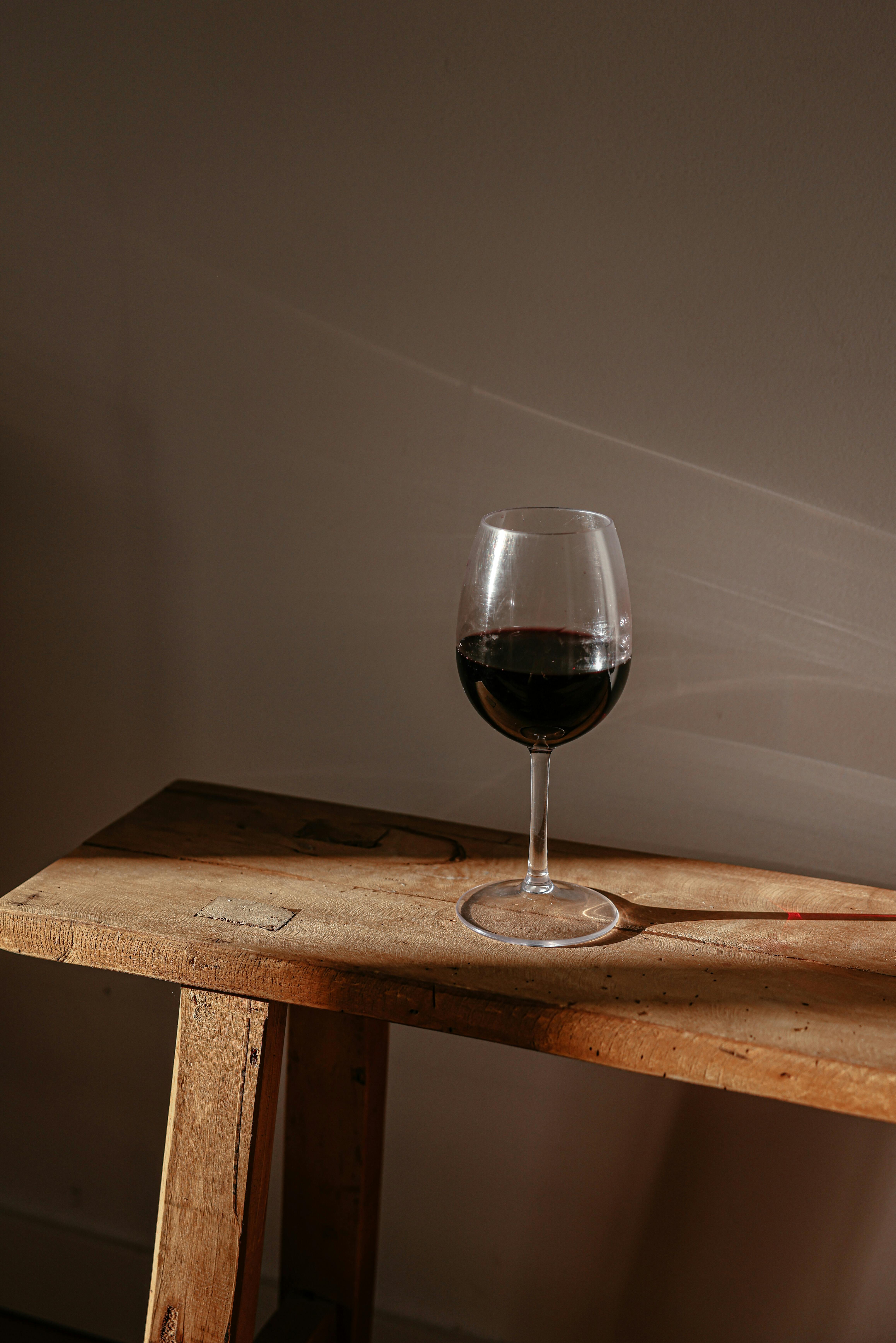 Free A Glass of Red Wine on a Wooden Bench Stock Photo
