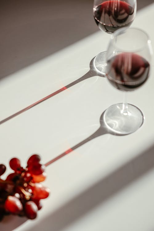 Wine Glasses and Grapes on White Surface