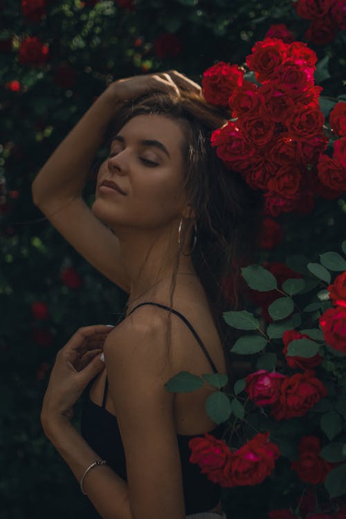 Beautiful Woman Posing Beside Red Roses