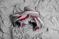 From above of pair of unisex trendy sneakers placed on gray creased fabric