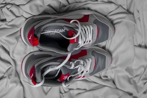 Top view of modern pair of sneakers for sport placed on gray fabric
