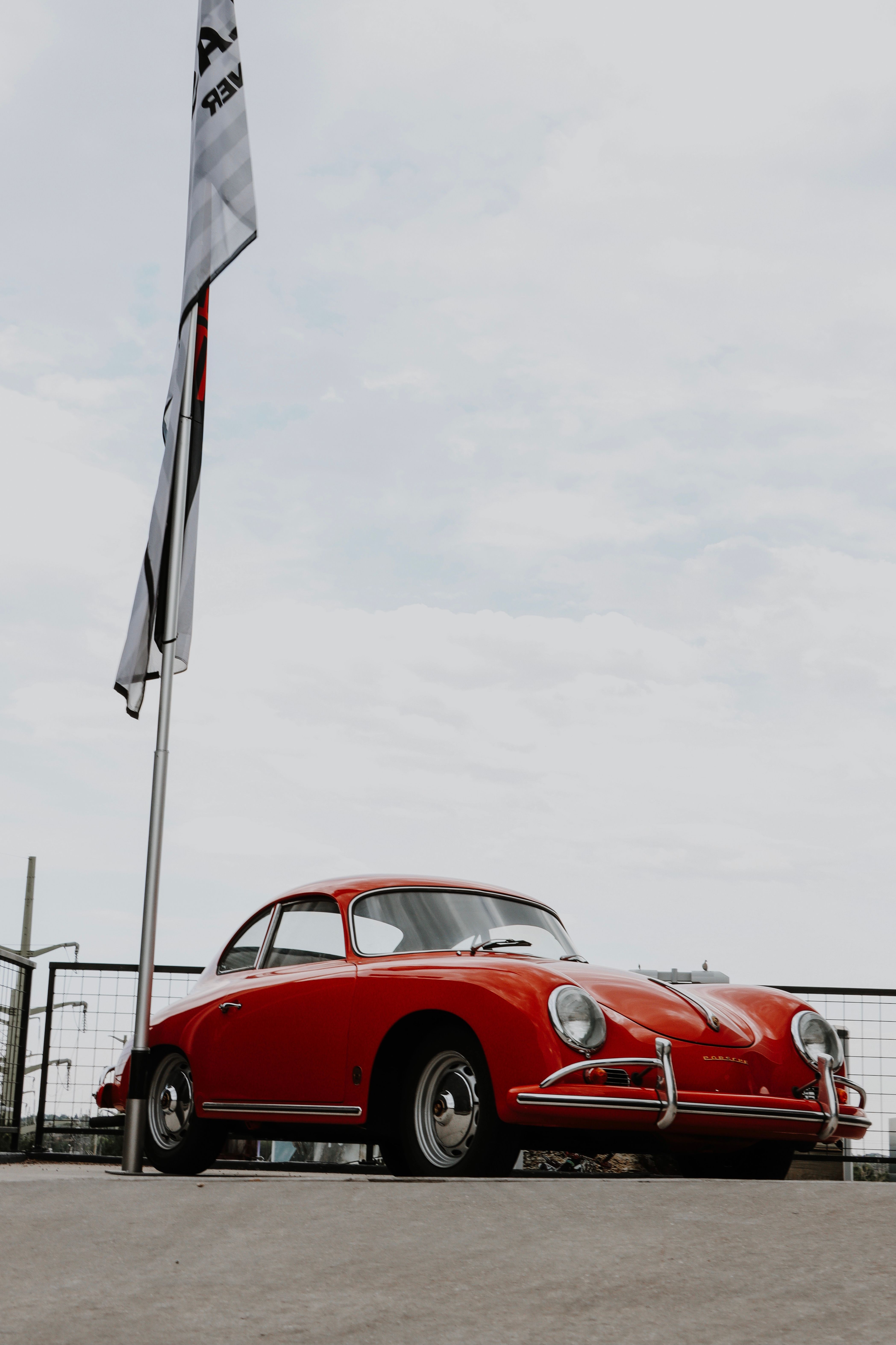 Classic Red Volkswagen Beetle on Coastal Road · Free Stock Photo