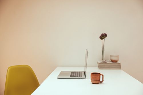 Free A serene minimalist workspace featuring a laptop and coffee on a white desk. Stock Photo