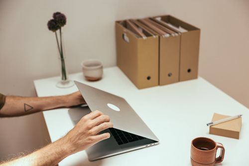 Free A clean and organized workspace featuring a laptop, coffee mug, and stationery, perfect for productivity. Stock Photo