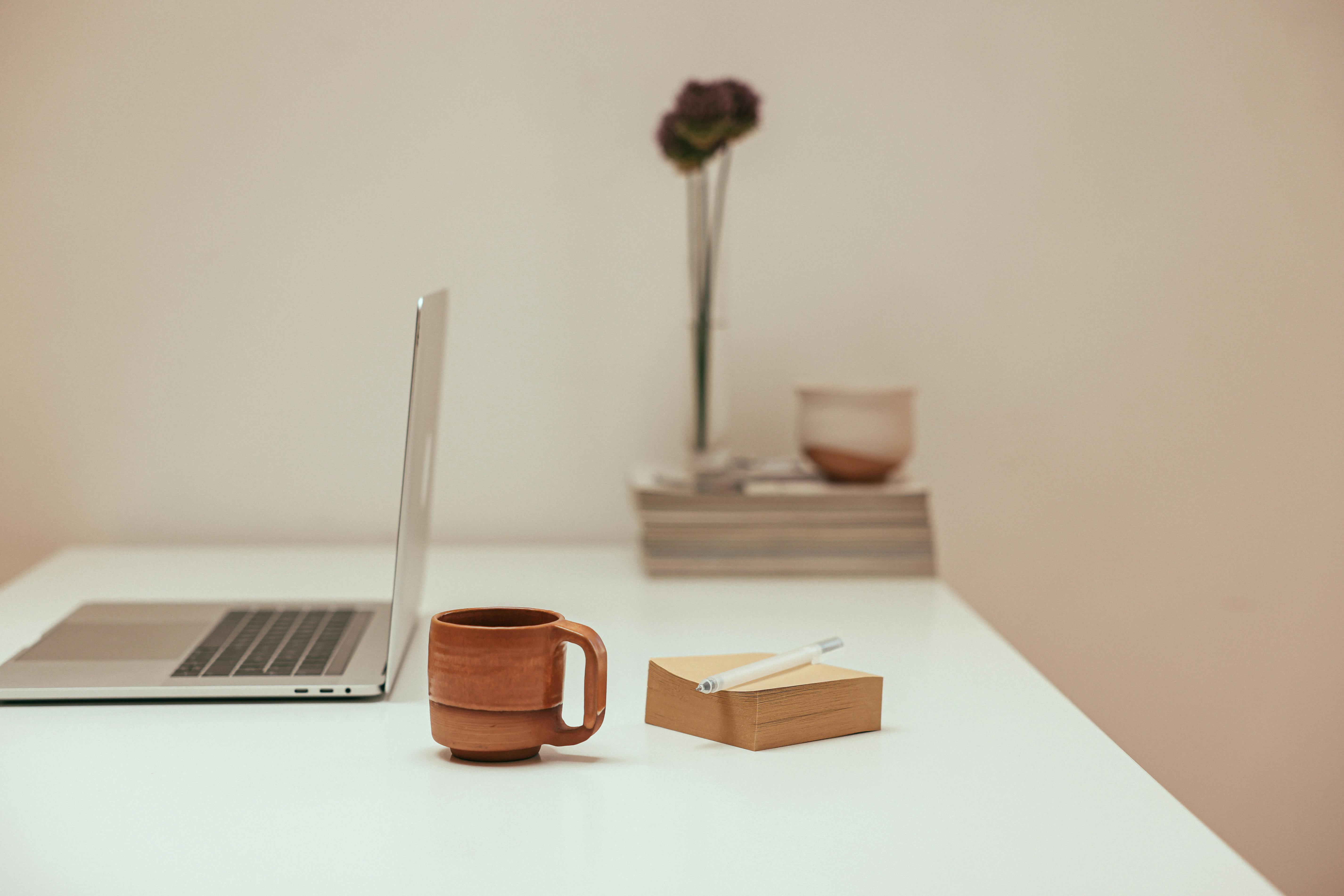 a coffee cup beside a notepad