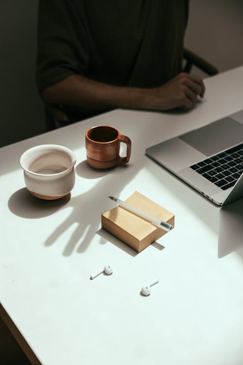 Free A Coffee Cup beside a Notepad Stock Photo