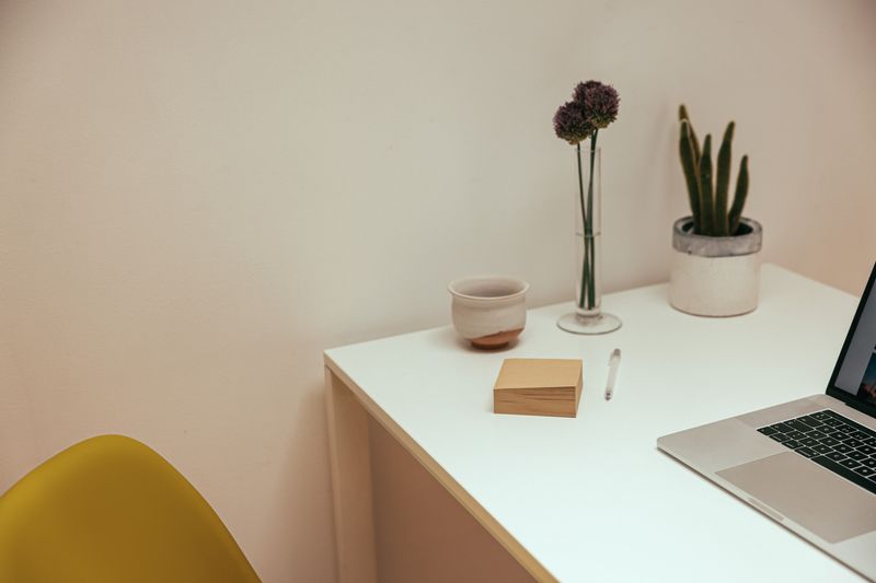 mismatched ceramic mugs hanging above a desk