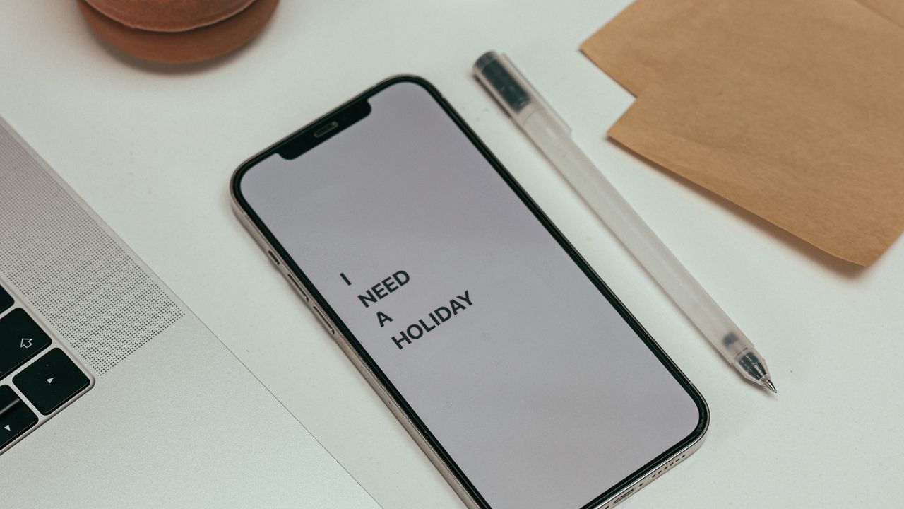 Minimalist digital workspace and phone Minimal desk with smartphone and laptop representing a simpler digital workspace