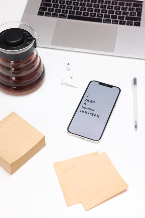 Free Flat lay of a modern work desk with coffee, laptop, smartphone, and earbuds. Stock Photo