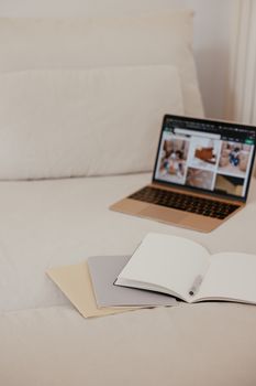 A serene workspace setup on a bed featuring a laptop and open notebooks for planning and creativity.