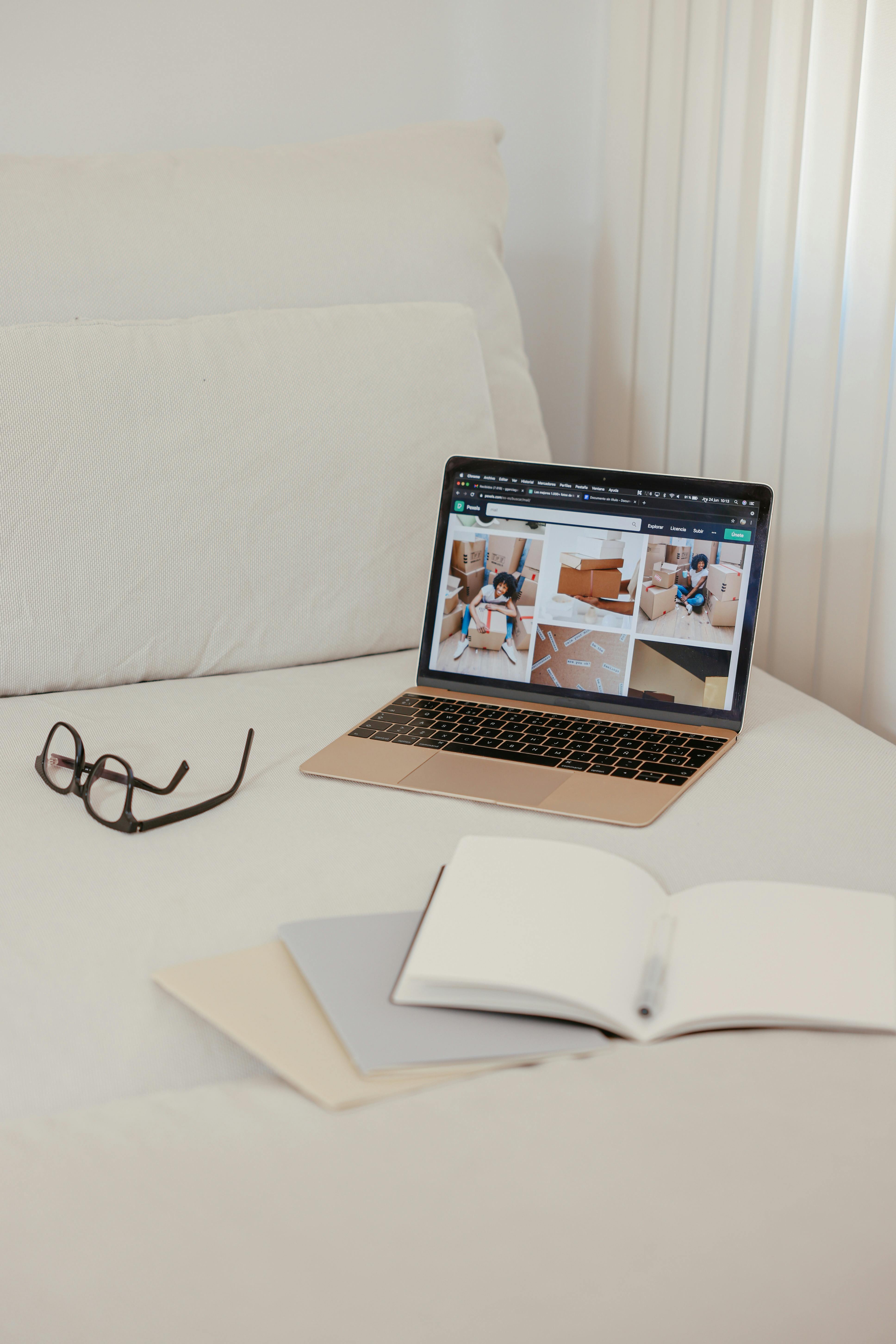 notebooks and a laptop on a bed