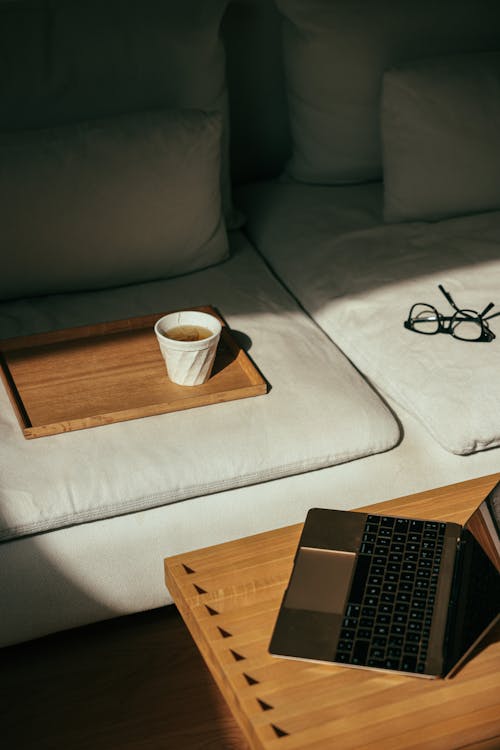 Free Cup on a Wooden Tray on the Couch Stock Photo