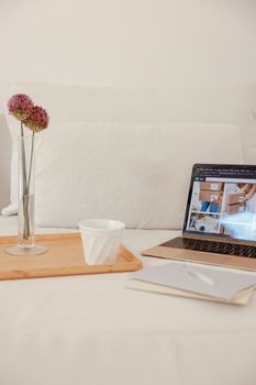 Comfortable home workspace setup with laptop, coffee, and decor in serene setting.