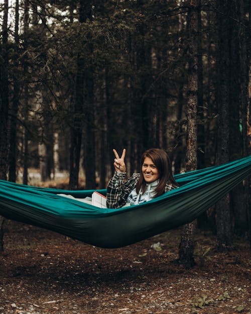 Free A Woman in a Hammock Doing a Peace Sign Stock Photo